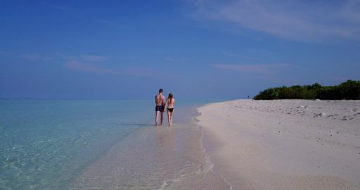 A beautiful shot of a Caucasian couple admiring on a beach in Rasdhoo Island, The Maldives