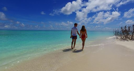 A beautiful shot of a Caucasian couple walking on a beach in Rasdhoo Island, The Maldives
