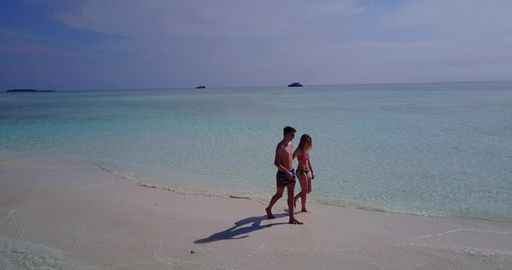 A beautiful shot of a Caucasian couple admiring on a beach in Rasdhoo Island, The Maldives