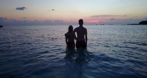 A beautiful shot of a Caucasian couple admiring the sunset in Rasdhoo Island, The Maldives