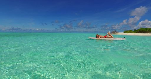 A Caucasian girl boarding on a paddleboard in Rasdhoo Island, The Maldives