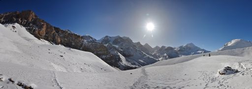 A panoramic view of beautiful mountains covered in snow against a blue sky