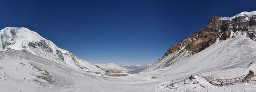 A panoramic view of beautiful mountains covered in snow against a blue sky