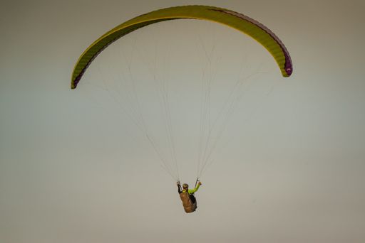 A beautiful shot of male parachuting with a clear sky in the background