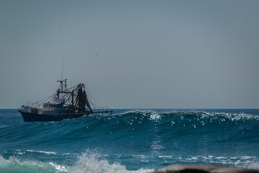 A wide shot of a sailing ship in the middle of the beautiful sea under the clear sky