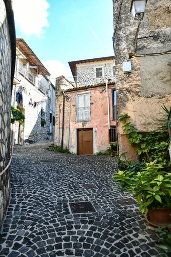 A closeup of a narrow street among the old stone houses of Villa Santo Stefano, a medieval town