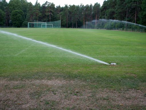 An in-ground sprinkler system watering the sports field