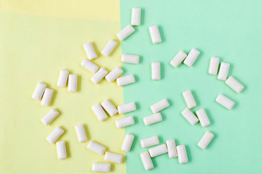 The White chewing gums on the yellow and green background, high angle view