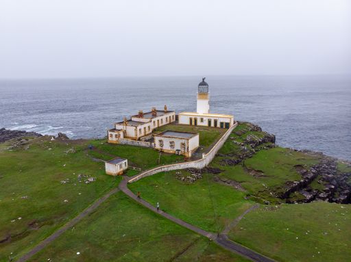 An aerial view of the Neist Point Lighthouse the sea in Scotland