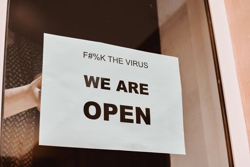 A white sign on the cafe window meaning that it is open after quarantine