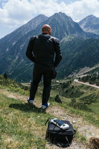 A vertical shot of a caucasian man with a drone in the Pyrenees