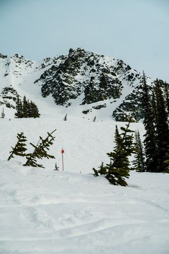 A vertical shot of a mountain range covered with snow against a cloudy sky
