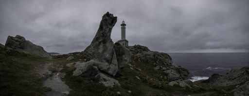A panoramic shot of Faro Punta Nariga under a cloudy dark sky