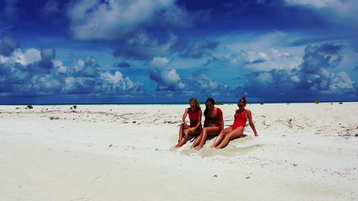 A group of women on the white beach of Fulhadhoo Island, The Maldives