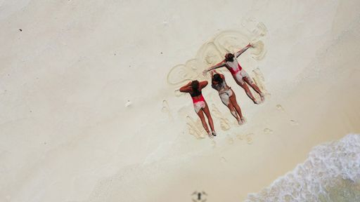 A top view of Caucasian women from Russia relaxing on sand in Fulhadhoo Island, the Maldives