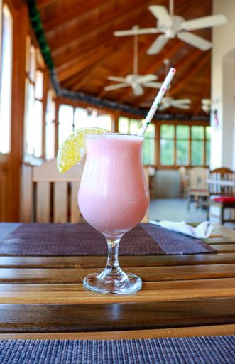 A closeup of a tasty pink cocktail on a table in a cafe
