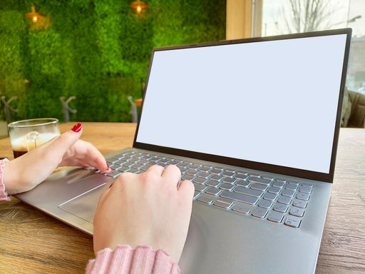 A person typing on the laptop with mockup screen - copy space