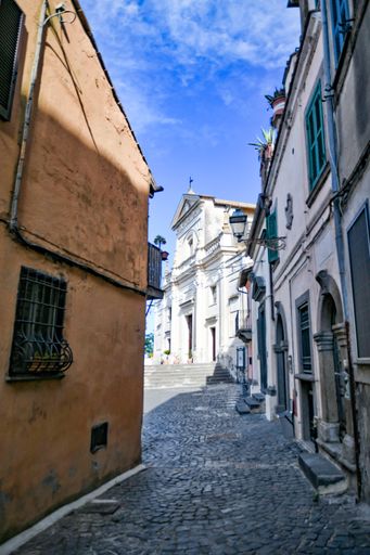 A vertical shot of a narrow street in Anguillara Sabazia with St. Mary of the Assumption church.