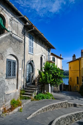 A vertical shot of a narrow street with old buildings. Anguillara Sabazia, Lazio, Italy.