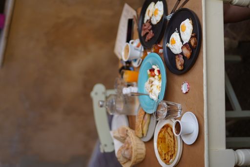 The vertical shot of a table with the morning breakfast meal - omelet, coffee, pancake, orange juice
