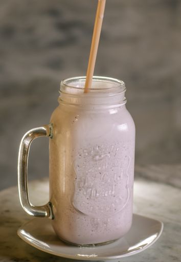 A portrait of a milkshake drink in a big mason jar