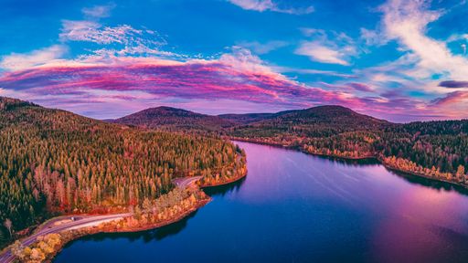 A mesmerizing view of a river along with autumn trees during a breathtaking sunset in Germany