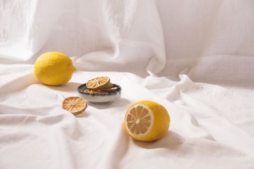 A shot of yellow lemons and dried fruit slices on a bright white background