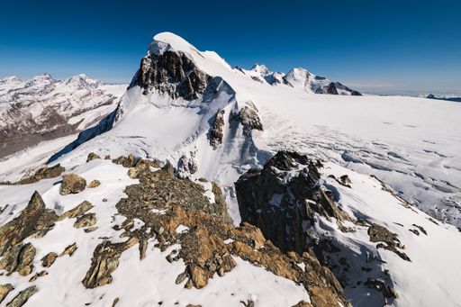 A breathtaking  shot of the snow-capped rocky mountains under a blue sky