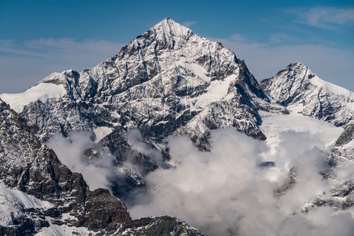 A breathtaking aerial shot of the snow-capped rocky mountains under a scenic sky
