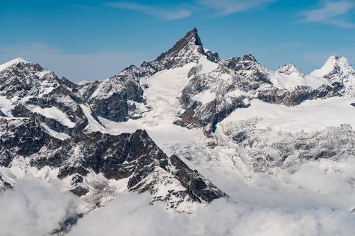 A beautiful scenery of high rocky mountains covered with snow under a clear blue sky in Switzerland