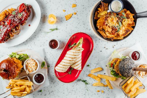 An overhead shot of a variety of fast foods and sauces on the table