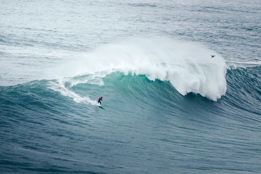 A professional surfer rides a giant wave