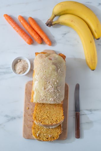 A top view of a cake with carrots and bananas on a table