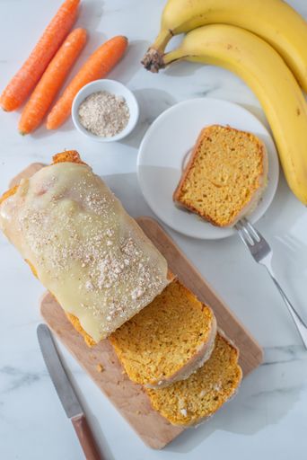 A top view of a cake with carrots and bananas on a table