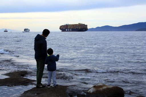 a photo of Father and sons watching argo ships at English Bay. Vancouver, British Columbia, Canada