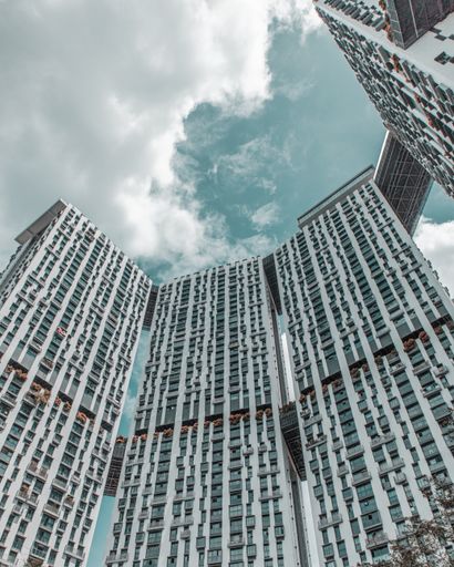 A low angle shot of a modern style skyscraper against the blue cloudy sky