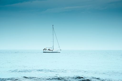 A beautiful shot of a lonely sailboat in a sea