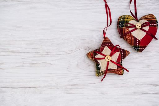 An overhead top view of a Christmas handmade star and heart ornaments on a wooden background