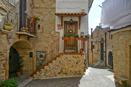 A beautiful shot of narrow street between the houses of a medieval village in the Puglia region on a sunny day, Ascoli Satriano, Italy