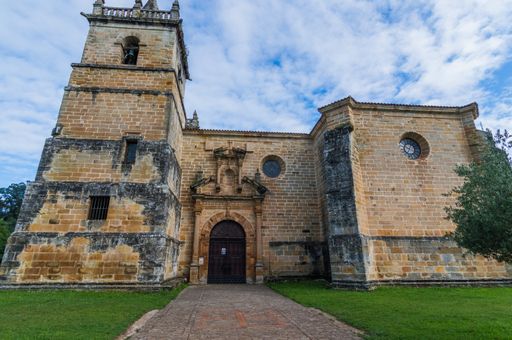 A low angle shot of a medieval building with a cloudy blue sky in the background