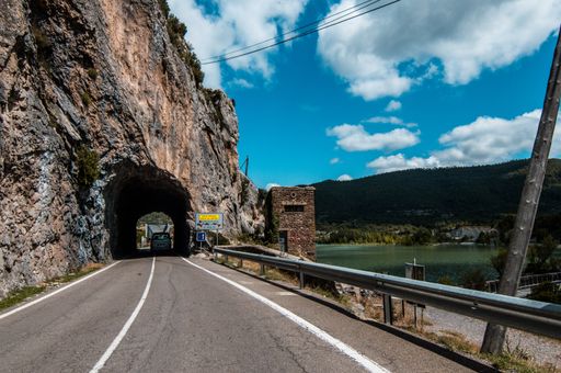 A road tunnel near the lake with a cloudy blue sky in the background