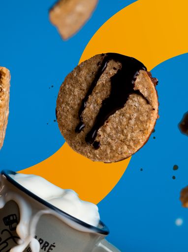 A dynamic food poster with a flying cookie and creamy milk against a yellow blue background