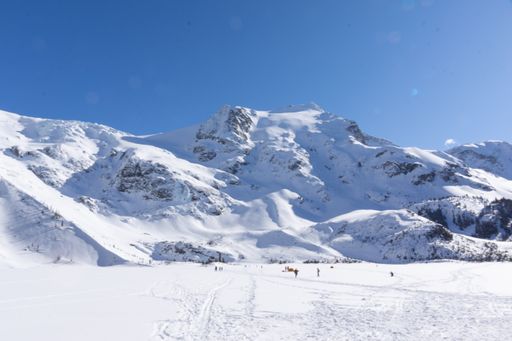 Several hikers leaving tracks on snowy valley landscape