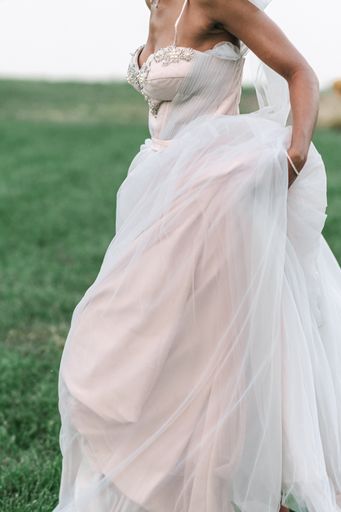 A bride wearing a pink and lavender colored wedding dress