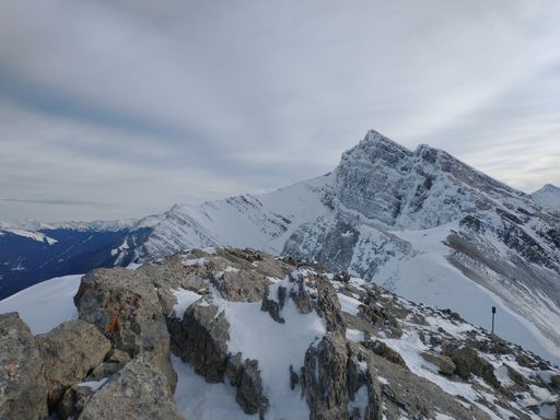 A beautiful shot of rocky mountains partly covered in snow.
