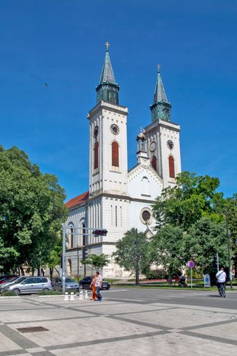 A vertical shot catholic church and beautiful square on a sunny day in the city of Sombor, Serbia