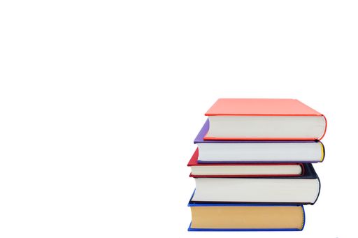 A closeup shot of five books stacked over one another on a white background