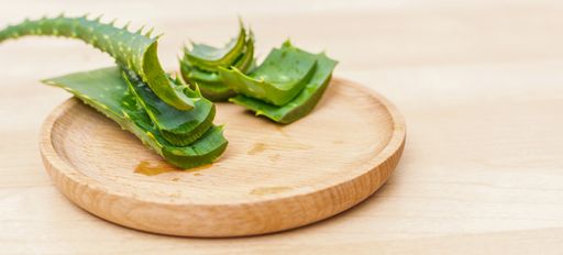 A closeup of slices of aloe vera leaves on a wooden plate