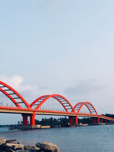 A vertical of the Valiazheekal Bridge in Azikal, India against the blue cloudy sky