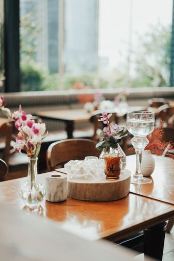 A selective focus shot of an elegant table setting with glasses and flowers